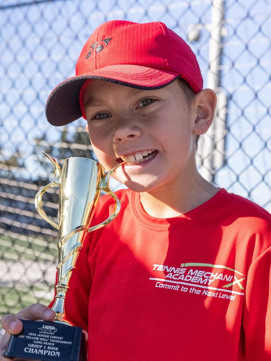 TMX Student biting trophy