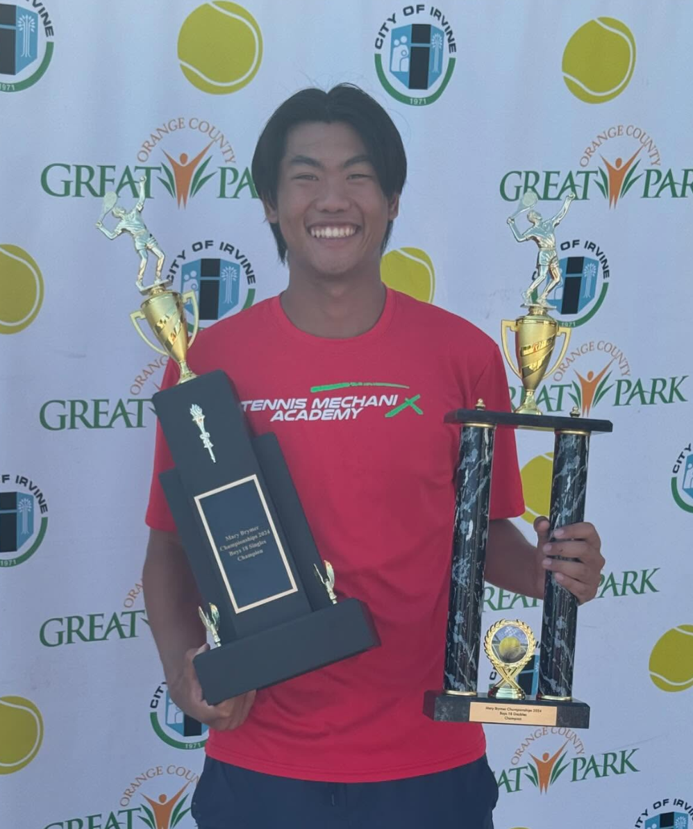 TMX student holidng up two trophies